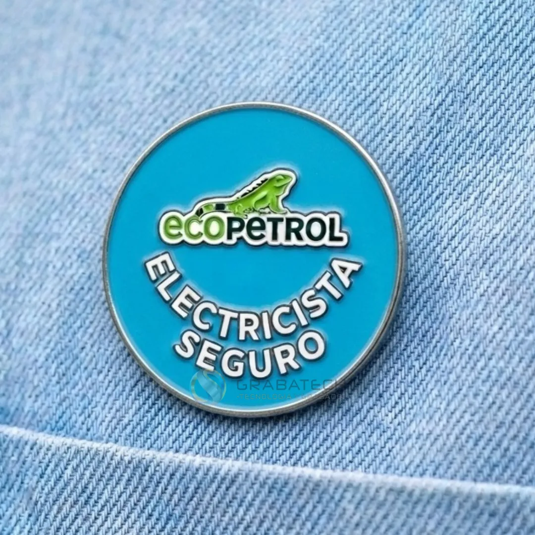 Pin circular de acero con esmalte azul turquesa sobre tela de jean