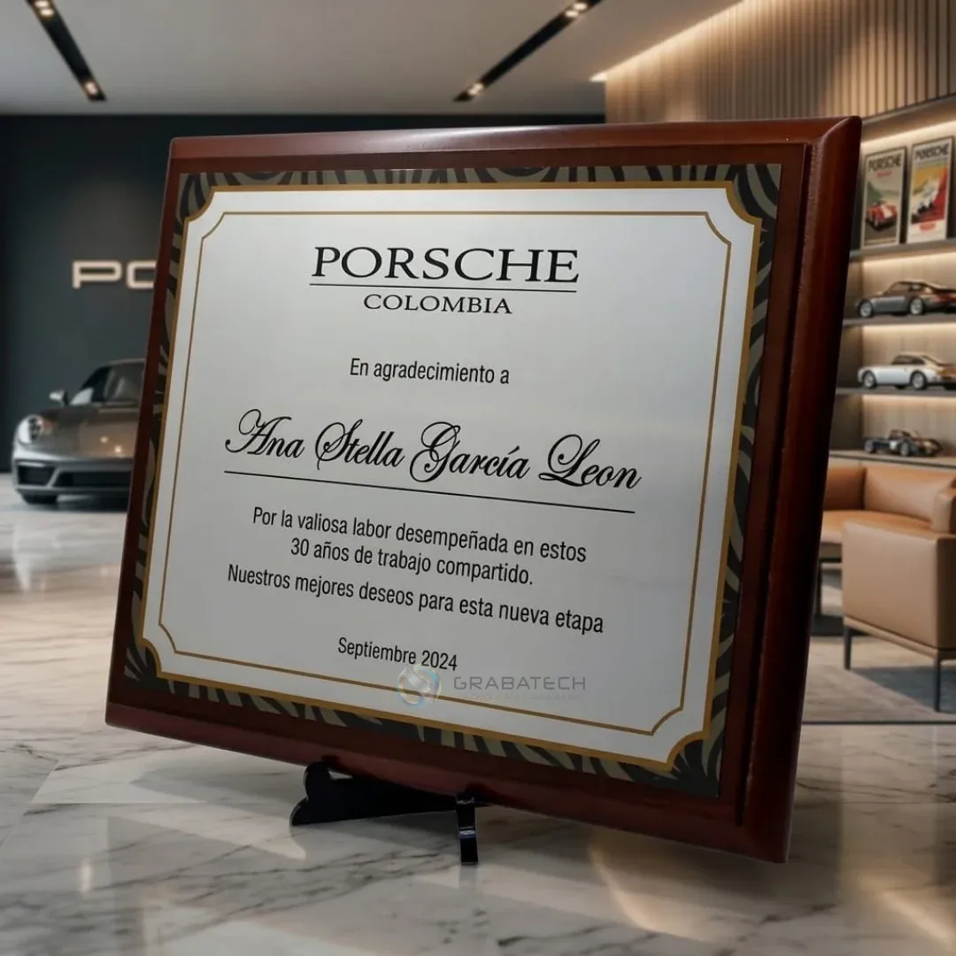 Placa conmemorativa sobre base de madera en exhibición, con lámina grabada