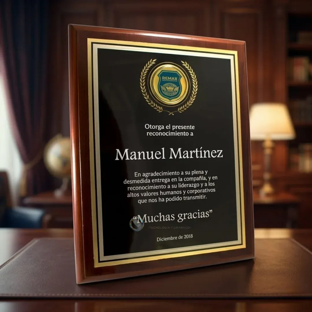 Placa conmemorativa con lámina negra, marco dorado y emblema