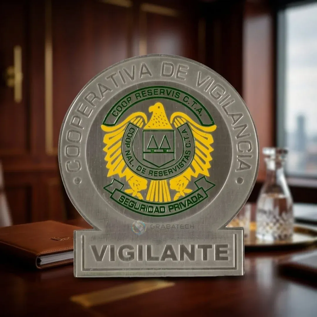Placa de vigilancia plateada con águila dorada y base con la palabra Vigilante